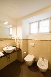 a bathroom with a sink and a toilet and a mirror at Hotel All'Arco in Trieste