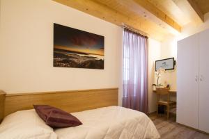 a bedroom with a bed and a window and a desk at Hotel All'Arco in Trieste