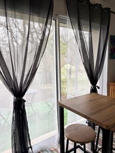 a table and two chairs in front of a window at Le refuge coloré in Gap +15 photos