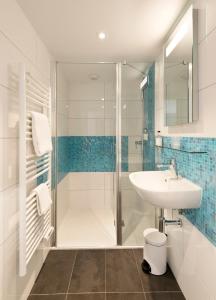 La salle de bains est pourvue d'une douche et d'un lavabo. dans l'établissement Hotel Atlantique, au Palais