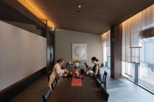 two people sitting at a table in a dining room at Mungyeong Sadamjae Stay in Mungyeong