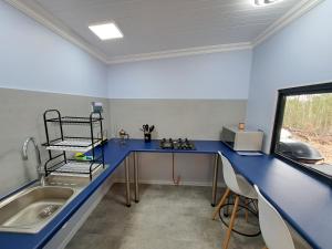 a kitchen with a blue counter and a sink at Zest Forest Retreat in Great Brak River