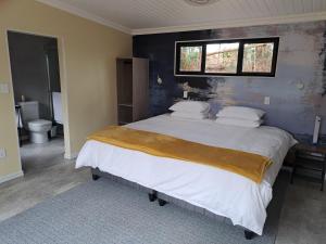 a bedroom with a large bed with a window at Zest Forest Retreat in Great Brak River