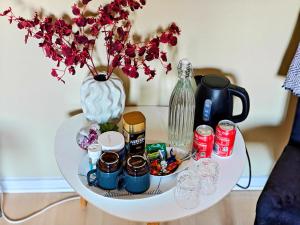 ein weißer Tisch mit einer Vase und Blumen darauf in der Unterkunft Tåning Bnb in Skanderborg