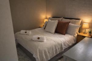 a bedroom with a bed with two towels on it at Tijger Haven in Tygerberg Hills