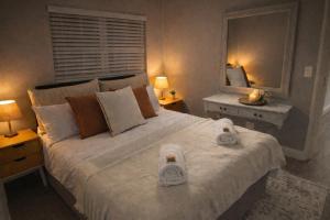 a bedroom with a large bed with towels on it at Tijger Haven in Tygerberg Hills