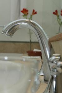 a bathroom sink with a chrome faucet at Hotel Xumec Mendoza in Mendoza