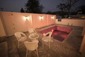 a patio with chairs and a small pool at night at Alpine Resort in Yelagiri