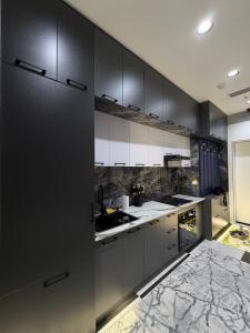 a kitchen with black and white cabinets and a sink at NEST ONE - Floor 15 in Tashkent