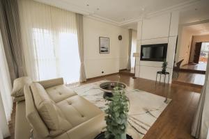 a living room with a couch and a tv at Alpine Resort in Yelagiri