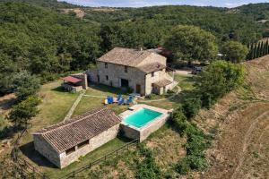 an aerial view of a house with a swimming pool at SCAPPO IN UMBRIA, casale al lago in Corbara