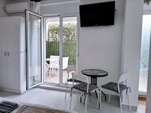 a living room with a table and chairs and a television at Apartments Kaludjerovic in Herceg-Novi