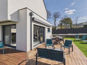 a deck with chairs and a table on a house at Superbe maison récente pour 8 avec jardin in Pléneuf-Val-André