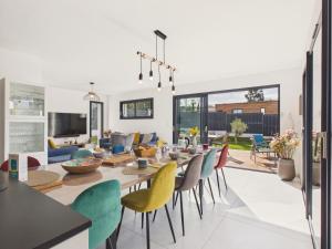 a dining room and living room with a table and chairs at Superbe maison récente pour 8 avec jardin in Pléneuf-Val-André