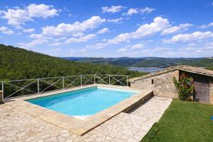 a swimming pool with a view of a mountain at SCAPPO IN UMBRIA, casale al lago in Corbara