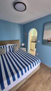 a blue bedroom with a large bed with a blue wall at Apartment Bunjo's Beach House in Trogir