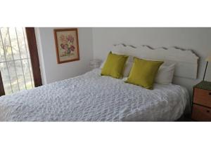 a bedroom with a white bed with two yellow pillows at Casa Rural Saint Joseph in Peralejo +31 photos