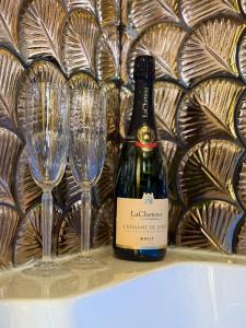 a bottle of wine sitting next to two wine glasses at Appartement Haussmann Spa et Ciné Experience in Nîmes