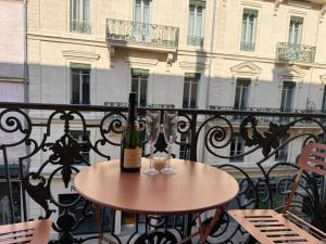 a bottle of wine sitting on a table on a balcony at Appartement Haussmann Spa et Ciné Experience in Nîmes