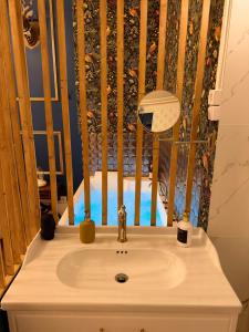a bathroom sink with a wooden fence behind it at Appartement Haussmann Spa et Ciné Experience in Nîmes +14 photos