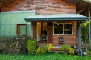a tiny house with a porch and two chairs at MaPin in Ban Thung Kong Mu