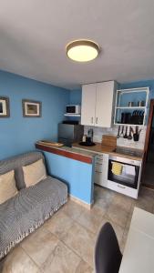 a kitchen with a couch and a counter in a room at Apartment Bunjo's Beach House in Trogir