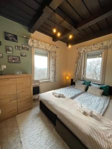 a bedroom with two beds and two windows at Tér Pince in Sümeg