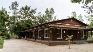 a small building with a small tree in front of it at Bardiya Nature Lodge in Belā +4 photos