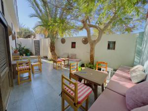 a patio with tables and chairs and a tree at Ocean Life Dahab in Dahab