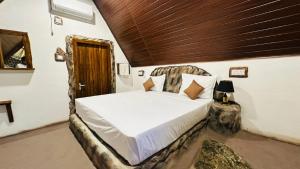 a bedroom with a bed with a wooden ceiling at Nature Nest Cabana in Sigiriya +49 photos
