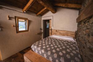 a bedroom with a bed in a room with a window at Rifugio Pra La Peira in Villar Perosa
