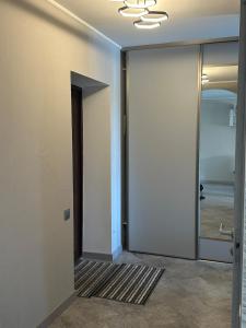 an empty hallway with a door and a mirror at Central Cozy Apartment in Ludza