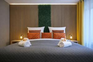 a bedroom with a large bed with towels on it at VonMos Moselblick Apartments in Kinheim +73 photos