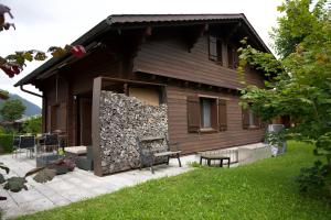 a wooden house with a bench and a patio at Chalet Enzian Wirzweli in Dallenwil
