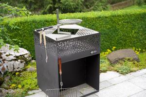 a black bird cage sitting in a garden at Chalet Enzian Wirzweli in Dallenwil