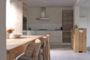 eine Küche mit einem großen Holztisch und Stühlen in der Unterkunft Moderne woning met 3 kamers voor 7 personen met gratis parking in Haaltert