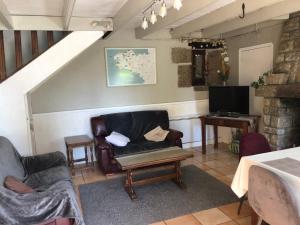 a living room with a couch and a table at Gites de la Haie in Plouégat-Moysan
