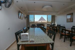 a dining room with a table and chairs and the pyramid at Guardian Guest House in Cairo