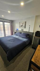 a bedroom with a large blue bed in a room at Hadrians wall studio in Carlisle