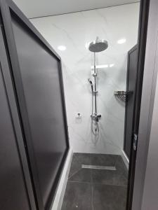 a shower with a glass door in a bathroom at Miran Hostel 2 Vokzal in Andizhan