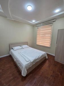 a bedroom with a large bed and a window at Miran Hostel 2 Vokzal in Andizhan