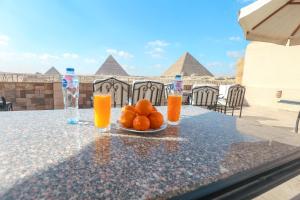a table with oranges and glasses of orange juice at Guardian Guest House in Cairo