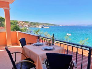 a table on a balcony with a view of the water at Apartments Beach in Šilo