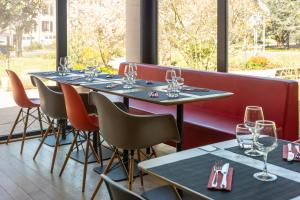 a row of tables in a restaurant with wine glasses at ibis Epinal Centre in Épinal