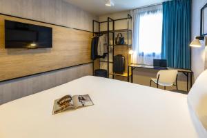 a hotel room with a bed and a tv at ibis Epinal Centre in Épinal