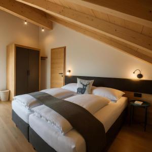 a large bed in a room with a wooden ceiling at Seelos - Alpine Easy Flats in Mieming