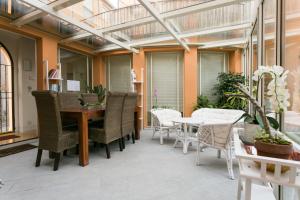 oranżerią ze stołem i krzesłami na patio w obiekcie Relais Pacinotti Apartments w Pizie