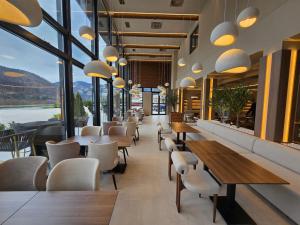 a restaurant with tables and chairs and large windows at Hotel IN in Žepče