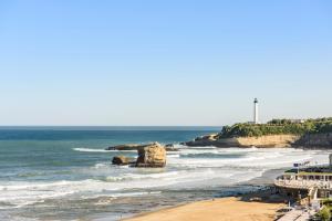 a view of a beach with a rock in the ocean at Hôtel Le Windsor Biarritz in Biarritz
