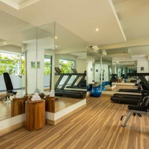 a gym with several treadmills and mirrors at Crystalkuta Hotel - Bali in Kuta